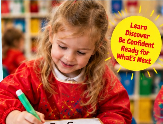 A young child drawing at a classroom table